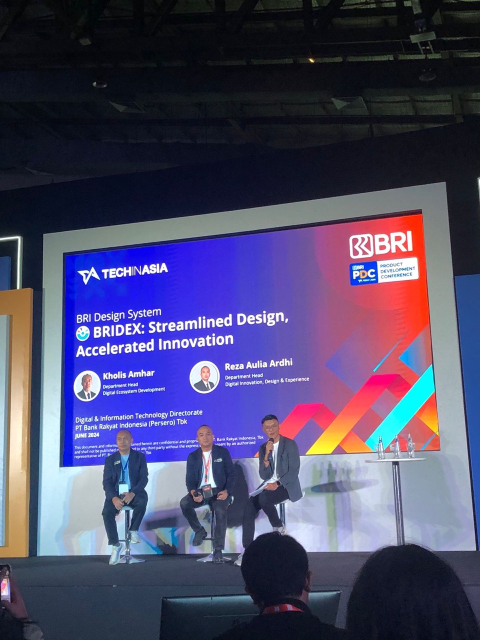 Panel discussion on stage with a BRIdex presentation at the Tech in Asia Product Development Conference